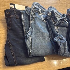Lot of 9 different types of womens jeans of assorted sizes.